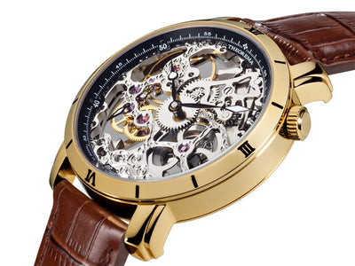 See-through skeletonized dial with gold case and brown leather band.